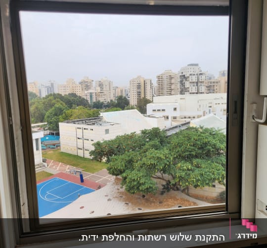 מסגרת חלון אלומיניום עם נוף עירוני ברקע